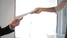 Hands transfer a piece of paper
